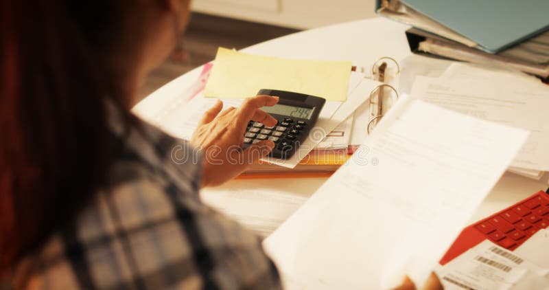 Femme agée à l'aide de la calculatrice pour les impôts et le budget à la maison images libres de droits Femme agée à l'aide de la calculatrice pour les impôts et le budget à la maison images libres de droits