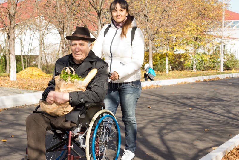 Femme aidant son père handicapé supérieur photo libre de droits Femme aidant son père handicapé supérieur photo libre de droits