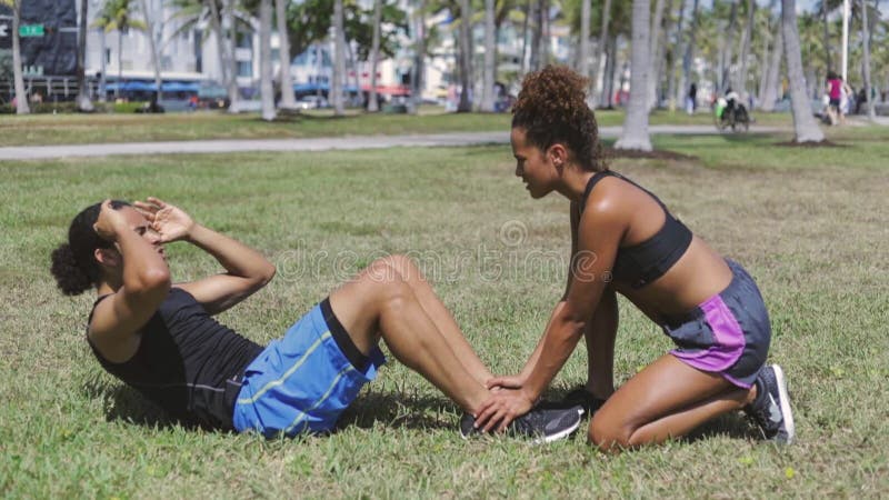 Femme aidant à l'ami avec l'exercice abdominal