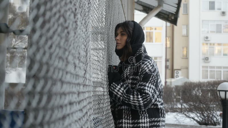 Femme ajustant l'écharpe près de la barrière nette banque de vidéos
