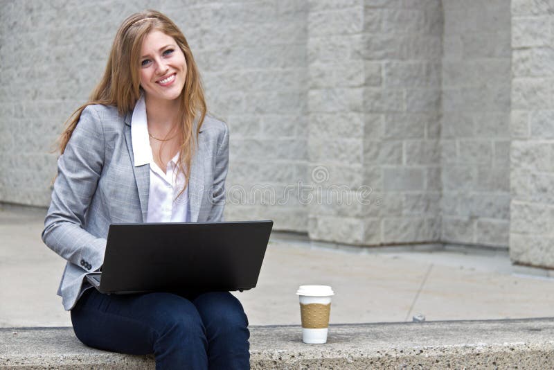 Friendly woman working on laptop outdoors. Friendly woman working on laptop outdoors