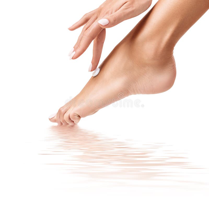 Femme appliquant la crème sur ses beaux pieds photographie stock libre de droits Femme appliquant la crème sur ses beaux pieds photographie stock libre de droits