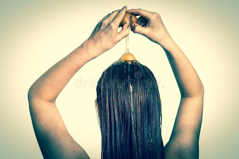 Femme appliquant le conditionneur d'oeufs sur ses cheveux - rétro style photo libre de droits Femme appliquant le conditionneur d'oeufs sur ses cheveux - rétro style photo libre de droits