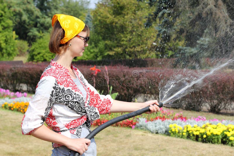 Femme arrosant les fleurs photos libres de droits Femme arrosant les fleurs photos libres de droits