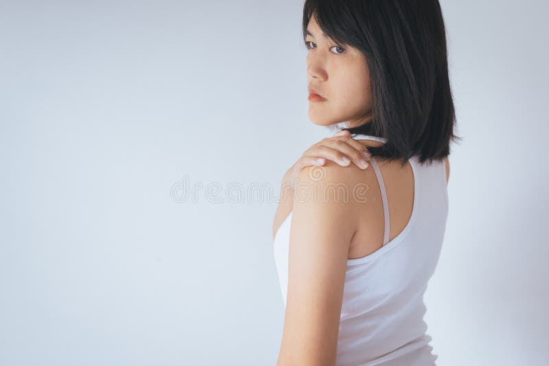 Femme asiatique avec douleur dans l'épaule, main femelle la touchant douloureuse image libre de droits Femme asiatique avec douleur dans l'épaule, main femelle la touchant douloureuse image libre de droits