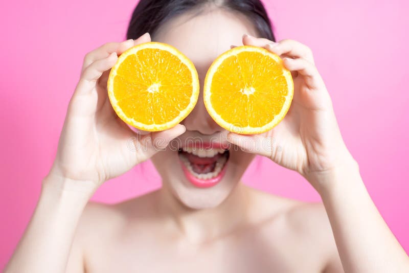 Femme asiatique avec le concept orange Elle souriant et tenant l'orange Visage de beauté et maquillage naturel D'isolement au-des image stock Femme asiatique avec le concept orange Elle souriant et tenant l'orange Visage de beauté et maquillage naturel D'isolement au-des image stock