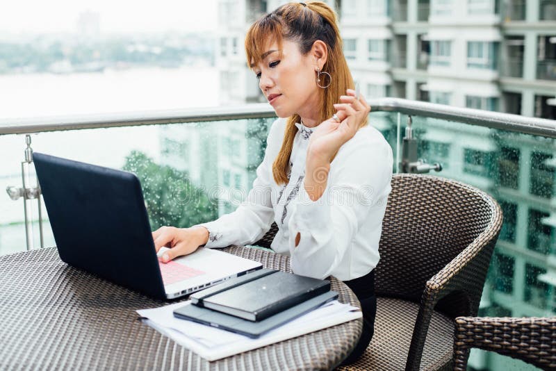 Femme asiatique d'affaires travaillant dans le bureau sur la plate-forme photos stock Femme asiatique d'affaires travaillant dans le bureau sur la plate-forme photos stock