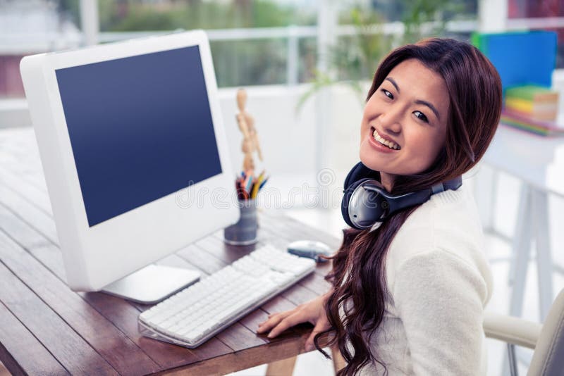 Femme asiatique de sourire avec des écouteurs autour de cou images stock Femme asiatique de sourire avec des écouteurs autour de cou images stock