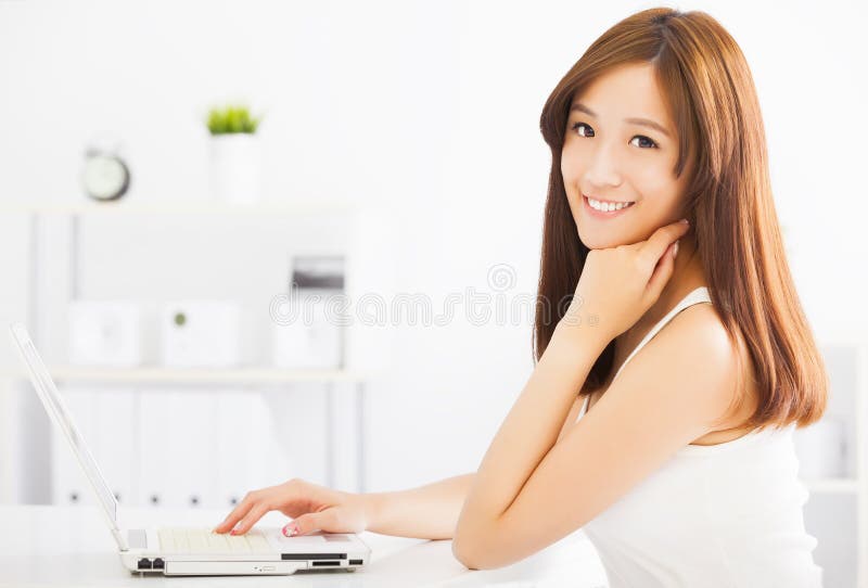 Femme asiatique de sourire avec l'ordinateur portatif image stock Femme asiatique de sourire avec l'ordinateur portatif image stock