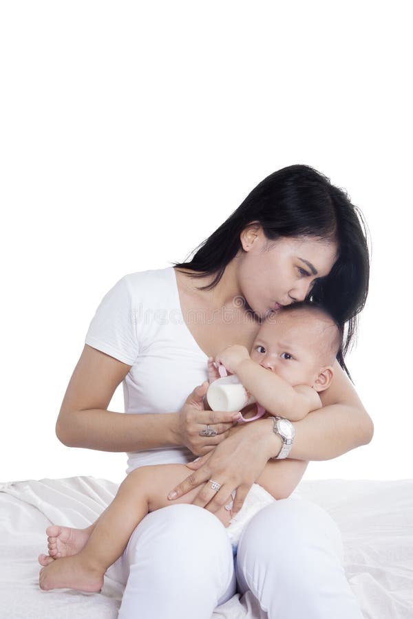 Femme asiatique embrassant son bébé sur le studio photos libres de droits Femme asiatique embrassant son bébé sur le studio photos libres de droits