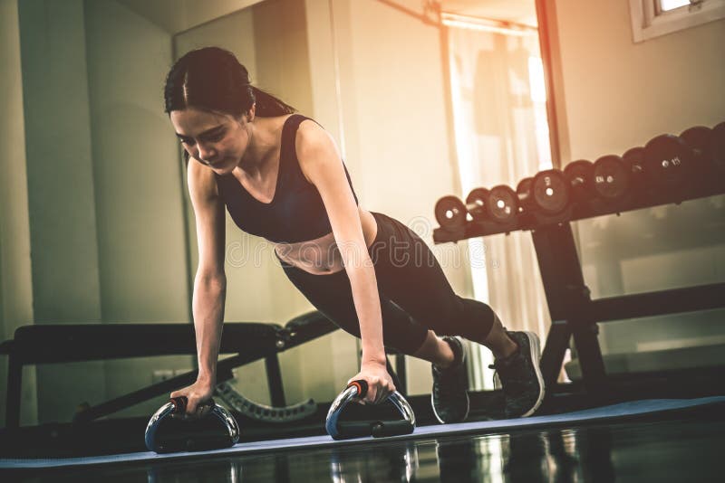 Femme asiatique forte faisant une planche dans un gymnase de forme physique photos libres de droits Femme asiatique forte faisant une planche dans un gymnase de forme physique photos libres de droits