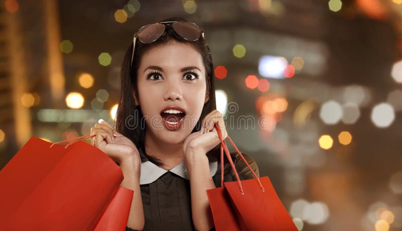 Femme asiatique heureuse avec le panier rouge célébrant Black Friday photographie stock Femme asiatique heureuse avec le panier rouge célébrant Black Friday photographie stock