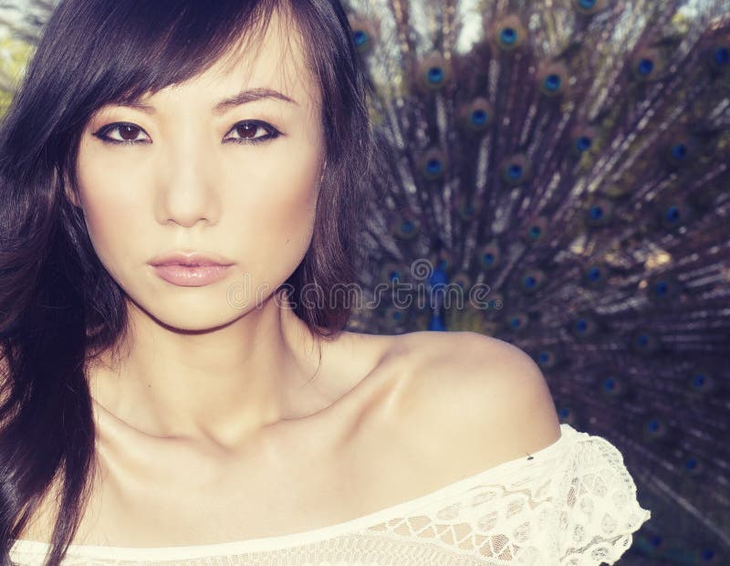 Femme asiatique posant près du paon photo libre de droits Femme asiatique posant près du paon photo libre de droits