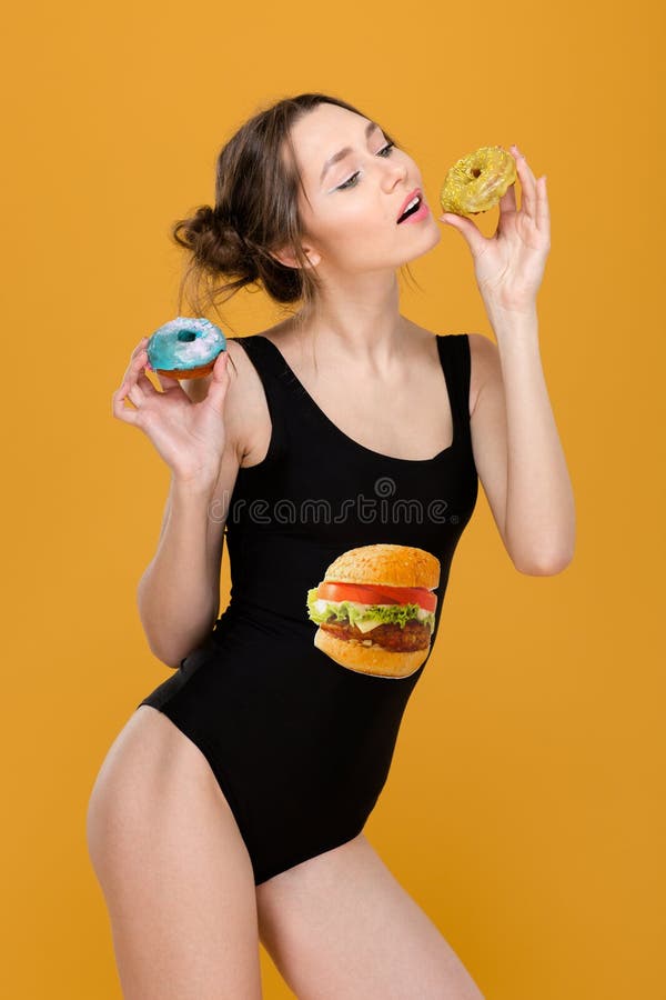 Femme attirante espiègle dans le maillot de bain noir de concepteur posant avec des butées toriques photos libres de droits Femme attirante espiègle dans le maillot de bain noir de concepteur posant avec des butées toriques photos libres de droits