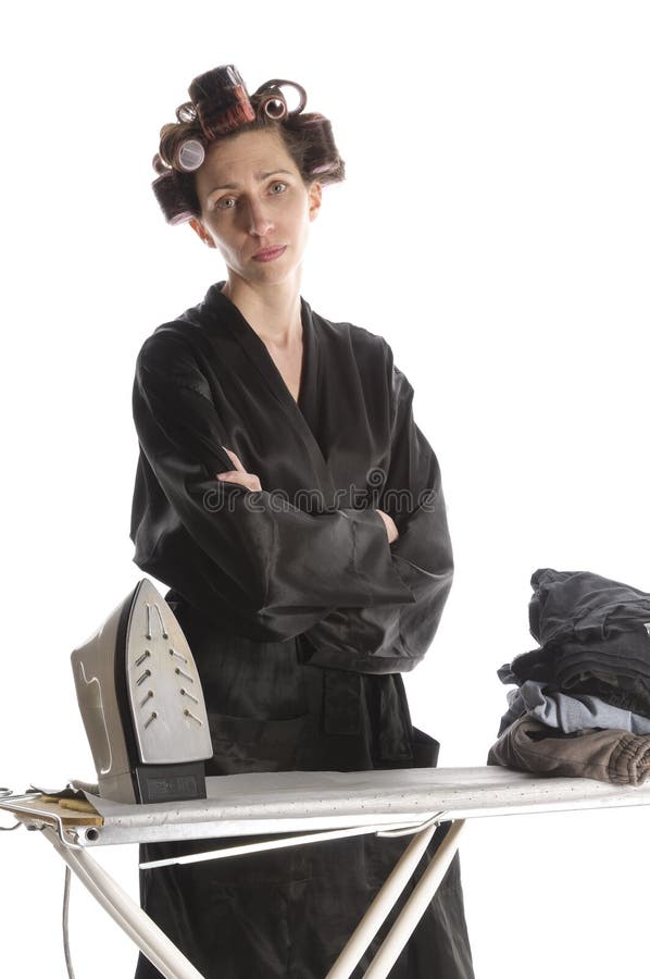 Femme au foyer désespérée repassant avec les bras croisés image stock Femme au foyer désespérée repassant avec les bras croisés image stock