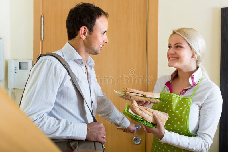 Happy young housewife preparing a delicious sandwich for her husband. Happy young housewife preparing a delicious sandwich for her husband