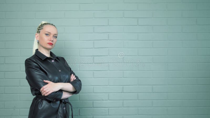 Femme aux tresses Afro dans une chemise en cuir. Mur de fond. Photo de studio banque de vidéos