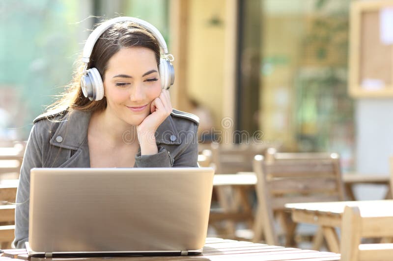 Femme avec casque dans la terrasse du bar avec ordinateur portable image libre de droits