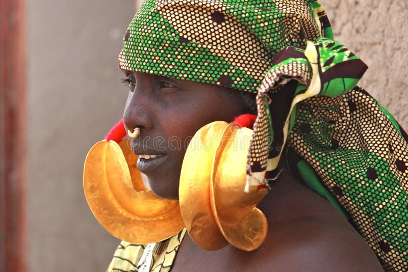 Woman in Africa with huge golden earrings. Woman in Africa with huge golden earrings