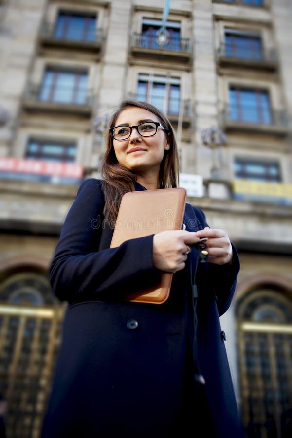 Femme avec des verres se tenant dans la ville avec le comprimé numérique photo stock Femme avec des verres se tenant dans la ville avec le comprimé numérique photo stock