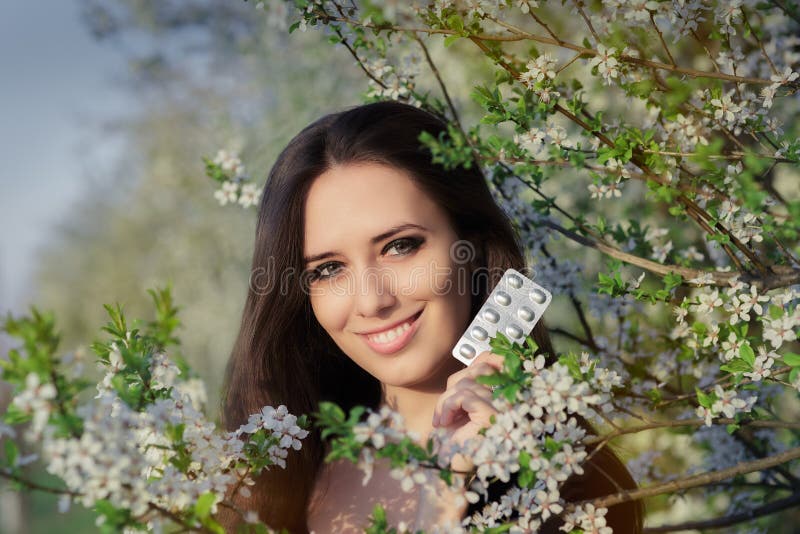 Femme avec l'allergie tenant l'anti décor de floraison allergique de pilules au printemps images libres de droits Femme avec l'allergie tenant l'anti décor de floraison allergique de pilules au printemps images libres de droits