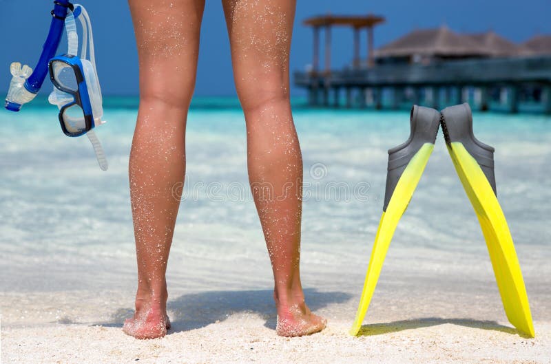 Femme avec l'équipement naviguant au schnorchel se tenant sur une plage maldivienne images stock Femme avec l'équipement naviguant au schnorchel se tenant sur une plage maldivienne images stock