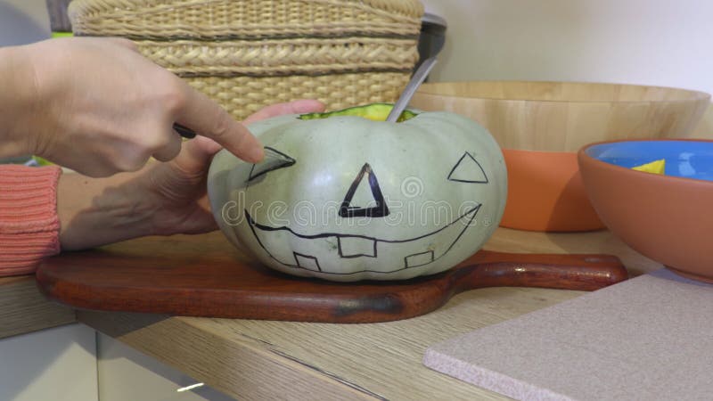 Femme avec la citrouille de coupe de couteau pour des vacances de Halloween