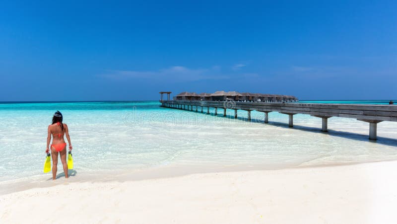 Femme avec la vitesse naviguante au schnorchel se tenant sur une plage maldivienne photos libres de droits Femme avec la vitesse naviguante au schnorchel se tenant sur une plage maldivienne photos libres de droits