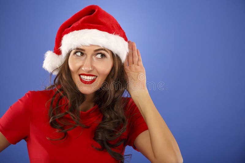 femme avec le chapeau de Noël avec la main à l'oreille photos stock femme avec le chapeau de Noël avec la main à l'oreille photos stock