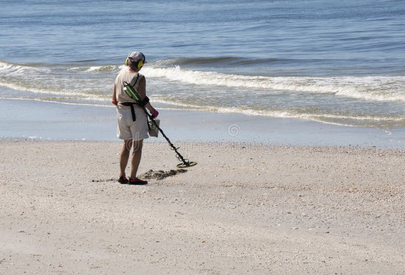 Femme avec le détecteur de métaux sur St Pete Beach, la Floride photographie stock Femme avec le détecteur de métaux sur St Pete Beach, la Floride photographie stock