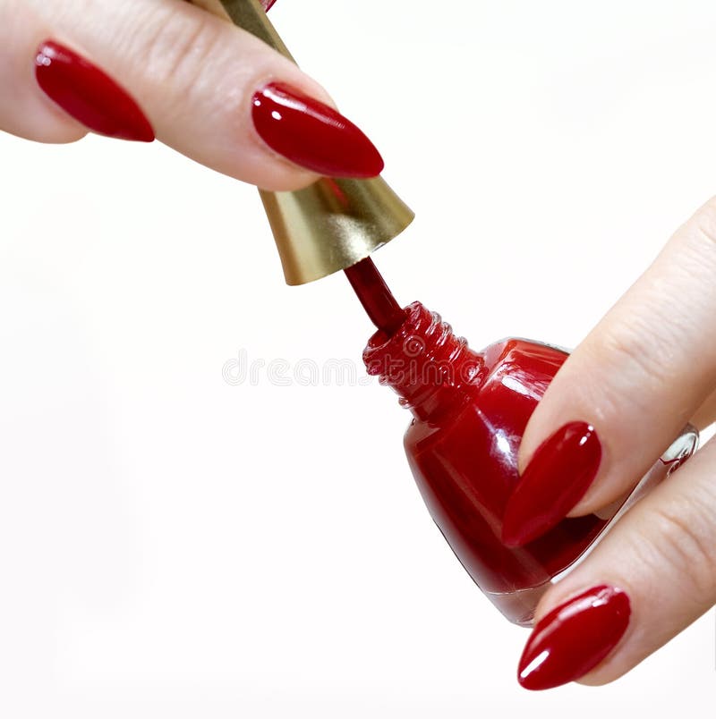 Closeup of woman with painted nails using bottle of red nail polish, isolated on white background. Closeup of woman with painted nails using bottle of red nail polish, isolated on white background.