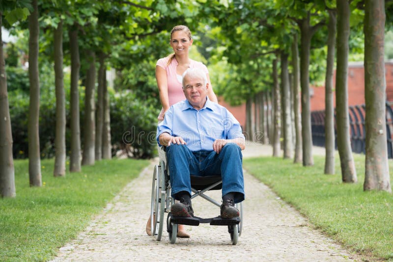 Femme avec son vieux père supérieur On Wheelchair photo libre de droits Femme avec son vieux père supérieur On Wheelchair photo libre de droits
