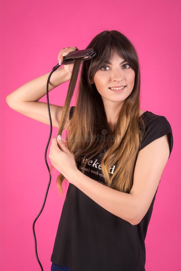 Femme avec un bigoudi de cheveux Fille avec les cheveux en désordre sur un fond rose photos stock Femme avec un bigoudi de cheveux Fille avec les cheveux en désordre sur un fond rose photos stock