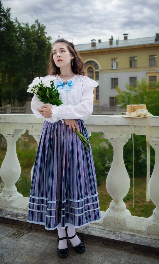 Femme avec un bouquet de chrysanthèmes blancs dans des vêtements vintage photographie stock