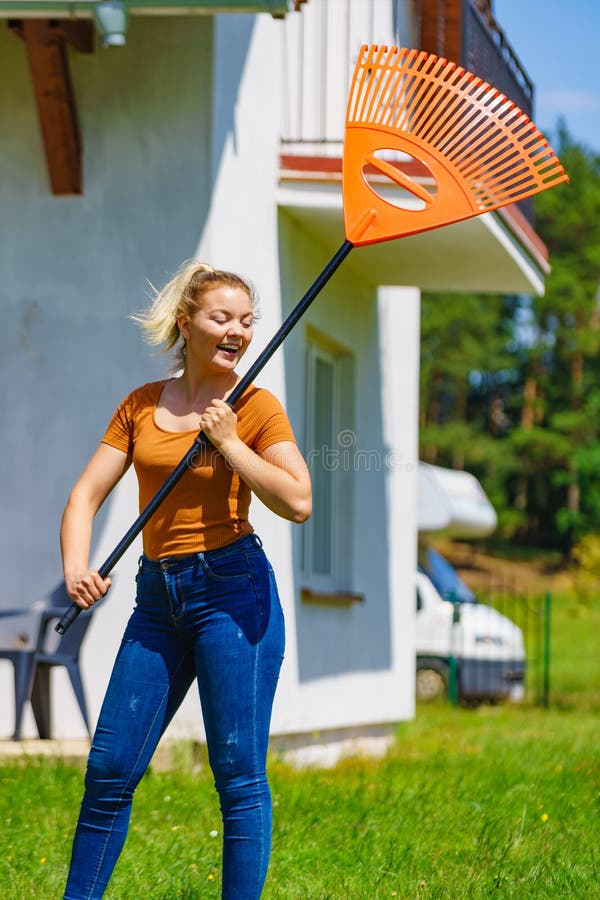 Femme avec un râteau dans le jardin images libres de droits
