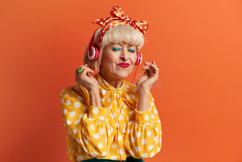 Femme aînée écoutant de la musique. grand-mère positive écouter la chanson préférée photographie stock libre de droits