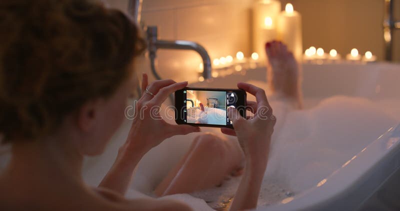 Femme bain et téléphone écran photo et détendre bougies et corps de nettoyage dans la baignoire médias sociaux et calme. femme banque de vidéos