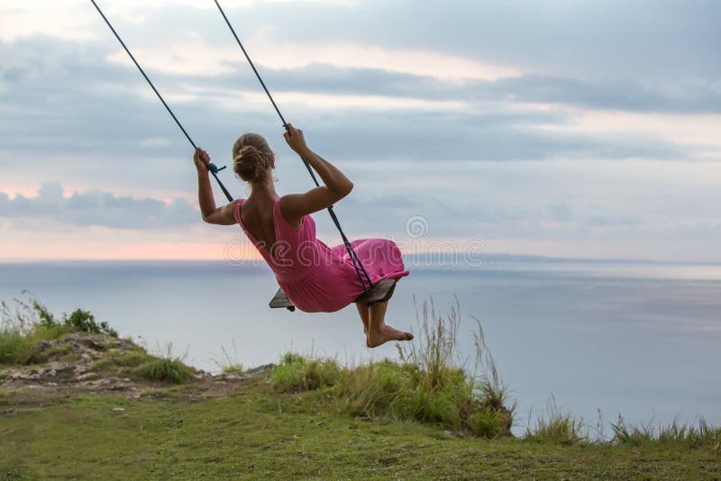 Femme balan?ant sur une oscillation sur une ?le tropicale photos libres de droits Femme balan?ant sur une oscillation sur une ?le tropicale photos libres de droits