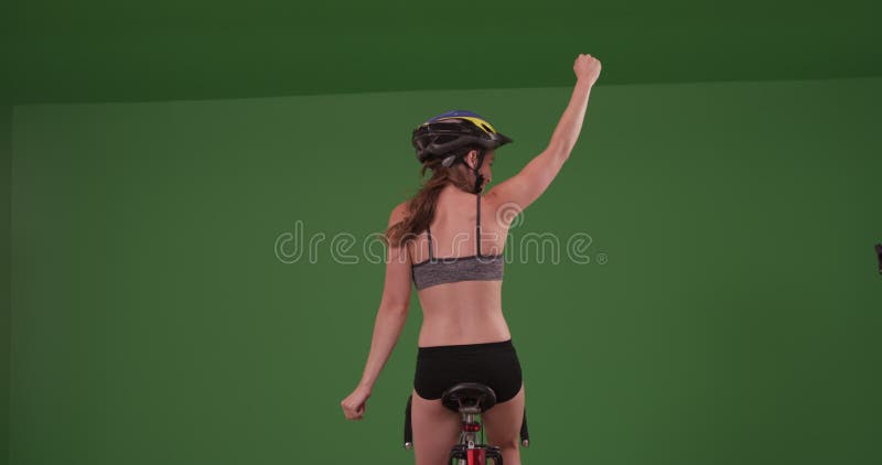 Femme blanche millénaire à vélo loin de la caméra sur écran vert