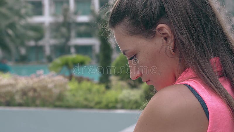Femme calme dans des positions de chemisier contre l'hôtel tropical brouillé
