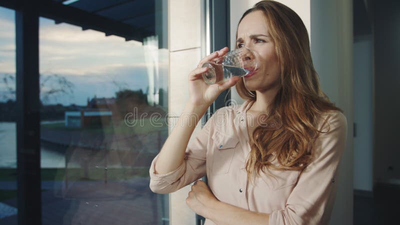 Femme concentrée restant près de la fenêtre panoramique L'homme de attente de jolie femme