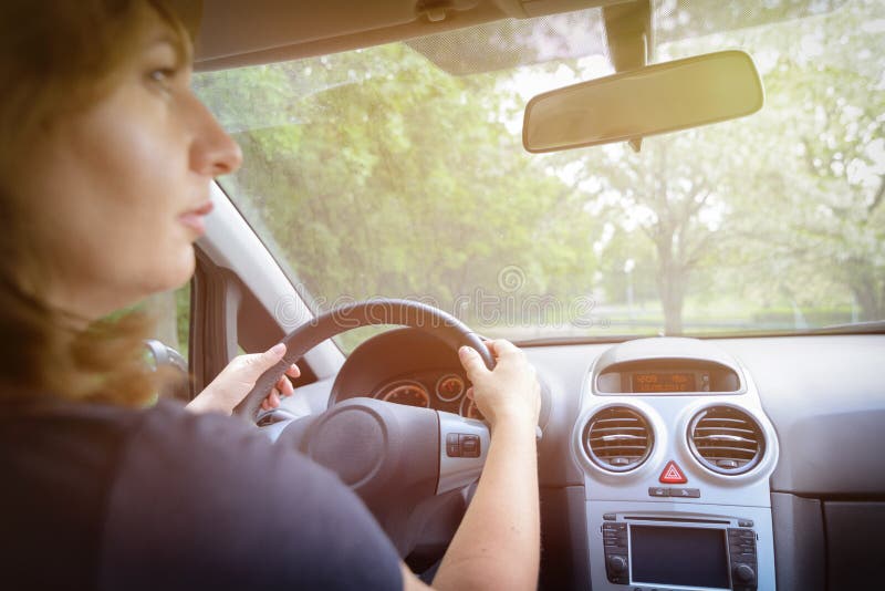 Femme conduisant une voiture, vue par derrière photographie stock Femme conduisant une voiture, vue par derrière photographie stock