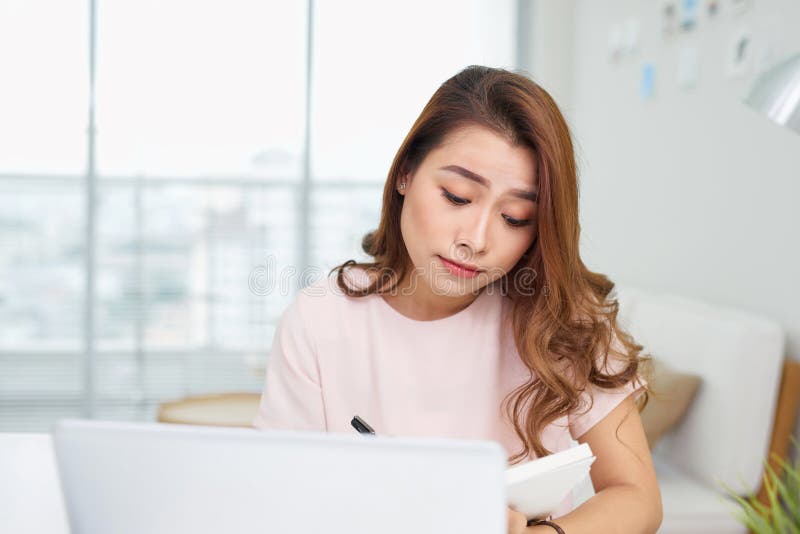 Femme confuse d'Asiatique Puzzled pensant dur concerné à la solution en ligne de problème regardant l'écran d'ordinateur portable photos libres de droits Femme confuse d'Asiatique Puzzled pensant dur concerné à la solution en ligne de problème regardant l'écran d'ordinateur portable photos libres de droits