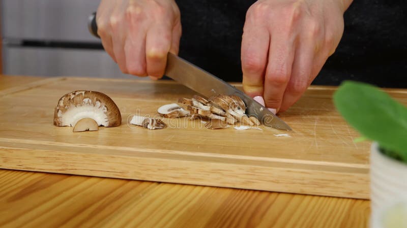 Femme coupant des champignons pour couper le conseil en bois