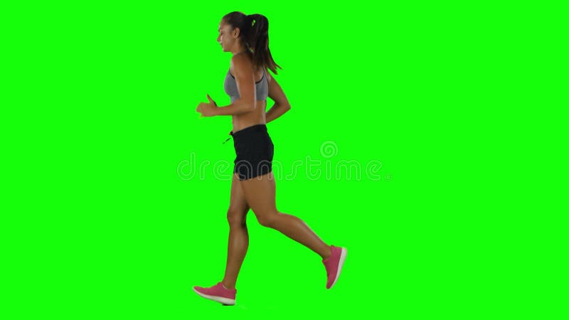 Femme courant dans l'habillement de sport Vue de côté Écran vert banque de vidéos