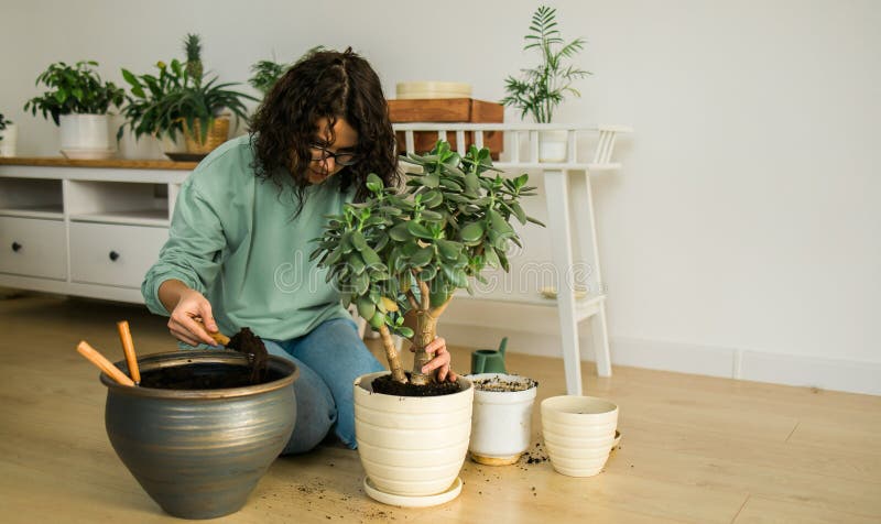 Femme afro-américaine arrosoir plante dans le nouveau pot