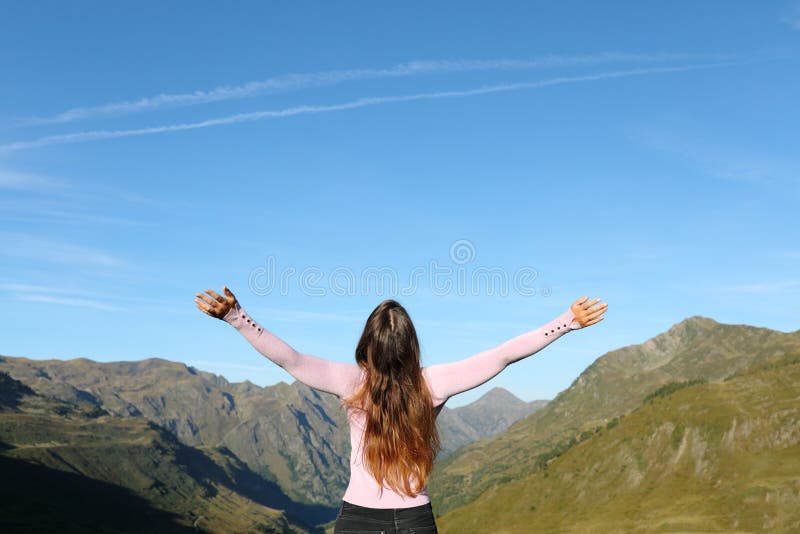 Femme célibataire déployant les bras dans la montagne