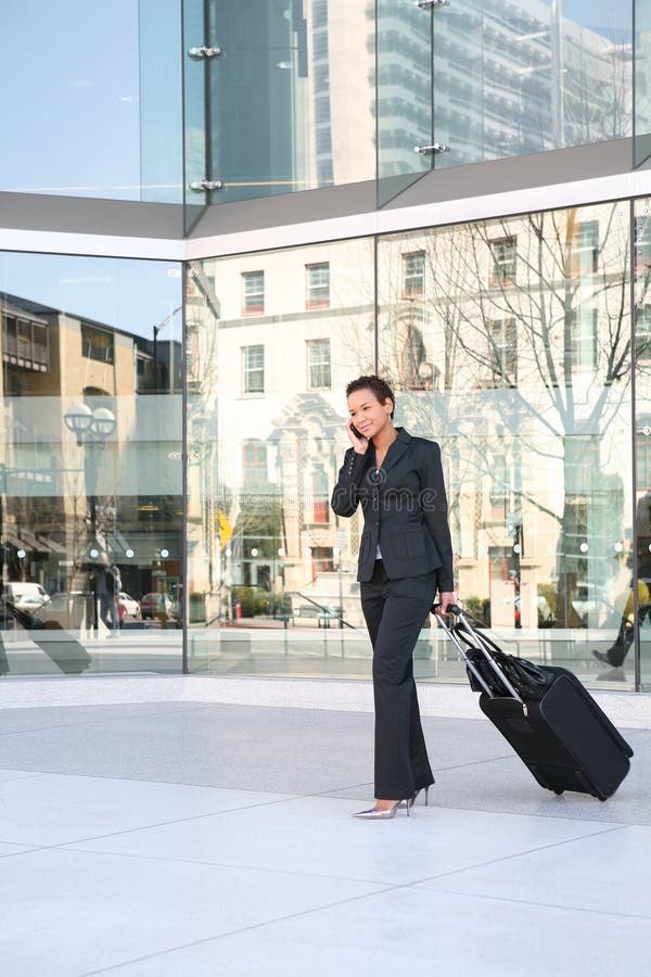 A pretty african american business woman travelling with suitcase. A pretty african american business woman travelling with suitcase