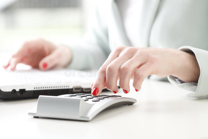 Close-up of businesswoman working on accountancy with calculator and laptop. Small business. Close-up of businesswoman working on accountancy with calculator and laptop. Small business.