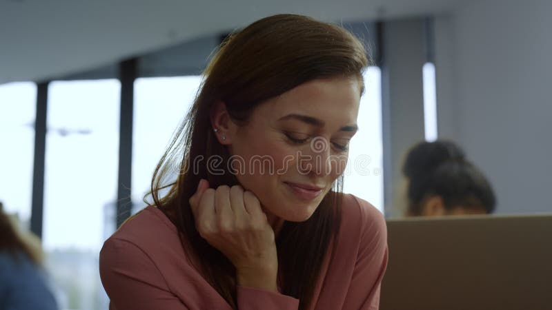 Femme d'affaires assise sur le lieu de travail. travailleur souriant à la recherche sur l'écran d'ordinateur portable banque de vidéos